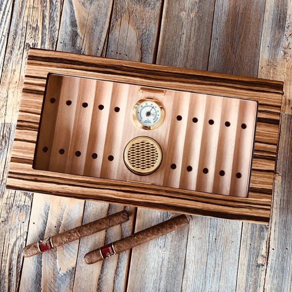 Glass top wooden desktop humidor with cigars stored inside at ideal humidity for long-term cigar storage